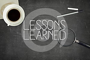 Lessons learned concept on black blackboard photo