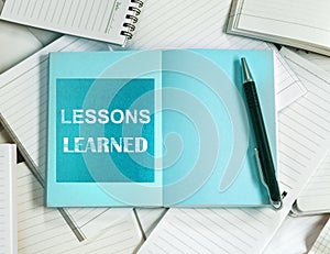 Lessons Learned concept with Manny empty notebook paper and note