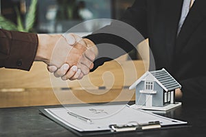 Lessor and tenants shake hands after signing real estate lease agreements..