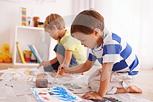 Let the creativity flow. two young boys painting pictures at home.