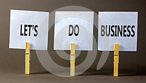 let is do business symbol. Concept words let is do business on beautiful white paper on clothespin. Beautiful grey table grey