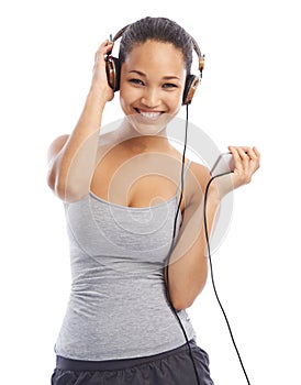 Let go with the gooves. Studio portrait of a young woman listening to music on headphones.