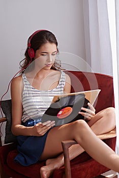 Let go and listen to music. a young woman listening to music while relaxing at home.