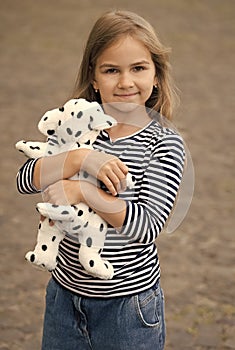 Let me play with you. Little kid cuddle toy dog outdoors. Toy friend. Childhood friend and friendship. Fun and game