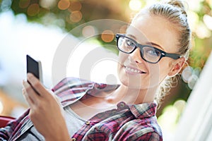 Let me see what my friends are up to. a young woman using her cellphone at home.