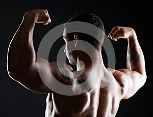 Let me share my strengths with you, itll make you look weak. athletic young man flexing his muscles while posing against