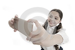 Let me take selfie. Girl cute long curly hair holds smartphone taking selfie white background. Child girl school uniform