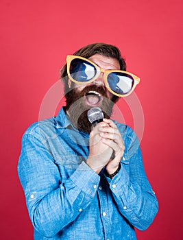 Let music flow in your heart. performer having fun. mature bearded man in funny party glasses sing song. brutal male