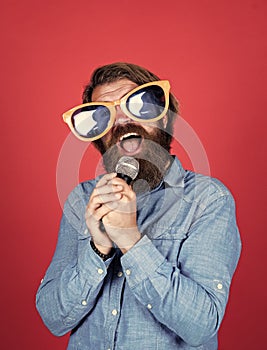 Let music flow in your heart. performer having fun. mature bearded man in funny party glasses sing song. brutal male