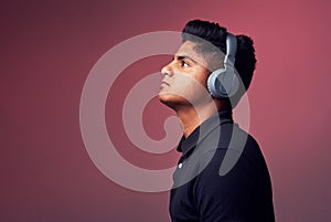 Let music take control. Studio shot of a handsome young man wearing headphones.