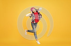 Let the music take you away. Energetic girl move to music. Little kid enjoy singing yellow background. Headphones