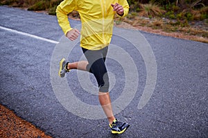 Let the road fly beneath your feet. High angle view of an athletes body running on a tarmac road.