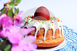 Let\'s celebrate Easter: Easter cake with a painted egg, bokeh of flowers, light background, space for text