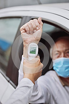 Let's check your temperature. Shot of an unrecognizable healthcare worker taking a patient's temperature at a