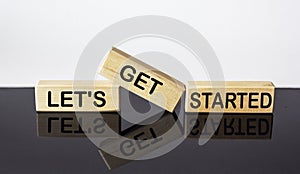 Let`s get started text on wood block and black and white background. business concept