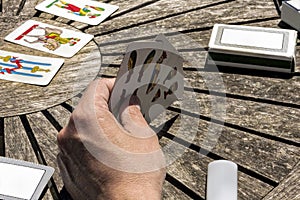 Let`s play cards outdoor in a wooden table