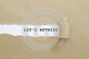 LET`S RETHINK word written under torn paper.