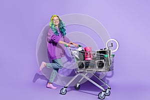 Let's swap. Vivid haired lady youth pull trolley with old stuff sell garage sale isolated over violet color background