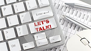 LET`S TALK text on a keyboard wirh chart and pencil