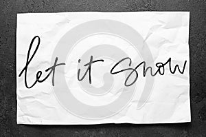 Let it snow. Lettering on crumpled white paper. Handwritten text. Inspirational quotes. photo