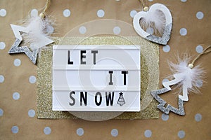 Let it snow text with Christmas ornaments. Christmas decorations on dot basic beige and golden background. photo