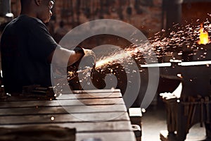 Let the sparks fly. a handsome young metal worker using a blowtorch while working inside a welding workshop.