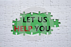 Let us help you symbol. White puzzle with words Let us help you. Beautiful green background. Business and Let us help you concept