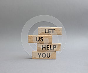 Let us help you symbol. Wooden blocks with words Let us help you. Beautiful grey background. Business and Let us help you concept