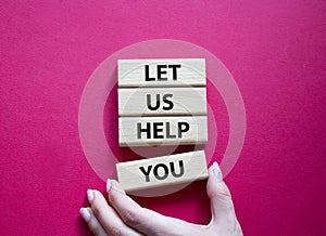 Let us help you symbol. Wooden blocks with words Let us help you. Beautiful red background. Businessman hand. Business and Let us