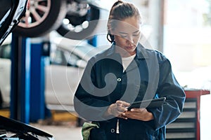 Let us send you a detailed quote on your vehicle. a female mechanic holding a digital tablet while working in an auto