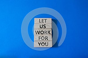 Let us work for you symbol. Wooden blocks with words Let us work for you. Beautiful blue background. Business and Let us work for