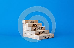 Let us work for you symbol. Wooden blocks with words Let us work for you. Beautiful blue background. Business and Let us work for