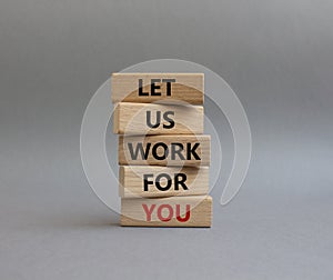 Let us work for you symbol. Wooden blocks with words Let us work for you. Beautiful grey background. Business and Let us work for