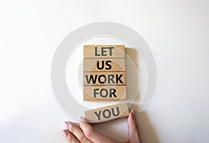 Let us work for you symbol. Wooden blocks with words Let us work for you. Beautiful white background. Businessman hand. Business
