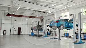 Let your car smile. Two lifted cars at service station prepared for diagnostics and repair indoors. Car service, repair