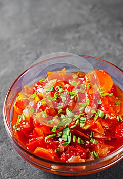 Letcho with tomatoes, peppers and carrots in glass bowl