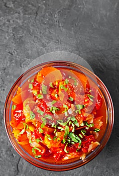 Letcho with tomatoes, peppers and carrots in glass bowl