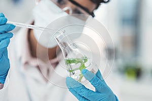 Lets add a few more drops in here. an unrecognizable female scientist dropping a liquid sample into a beaker containing