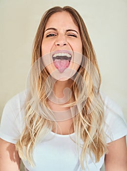 Lets be silly together. Portrait of an attractive young woman sticking out her tongue.