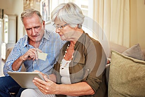 Lets buy something...a senior couple shopping online on their tablet.