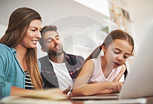 Lets chat with grandma and grandpa. a happy married couple and their young daughter using a laptop together at home.