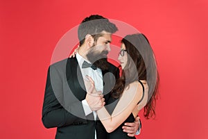 Lets dance tonight. Elegant couple in love tender hug dancing red background. Happy together. Man in tuxedo and woman photo