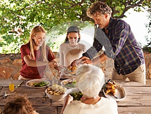 Lets eat. A view of a family preparing to eat lunch together outdoors.