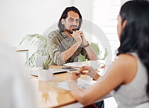 Lets get down to discussing business. a young businessman having a meeting with his colleague in an office.