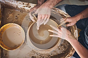 Lets get our hands dirty. an unrecognisable man and woman working with clay in a pottery studio.