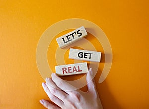 Lets get real symbol. Concept words Lets get real on wooden blocks. Beautiful orange background. Businessman hand. Business and