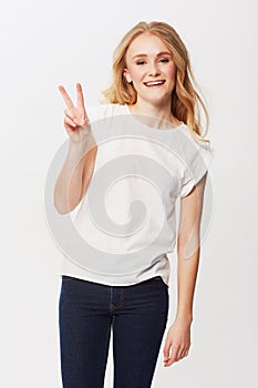 Lets give peace a chance. Casual young woman showing the peace sign with a smile.