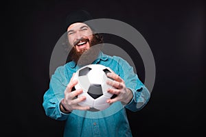 Lets go play football. Happy bearded man holding soccer ball and looking at the camera