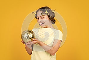 lets have fun on retro party. disco ball decoration. lovely girl with disco ball. Fashion girl pose in curlers on yellow