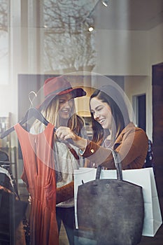 Lets have a little fashion fun. two best friends out shopping in a clothing store.